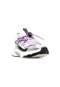 Zapatillas deportivas con una combinación de malla blanca y material sintético plateado, con acentos negros y cordones morados. Suela gruesa con dibujo texturizado.