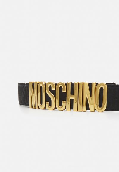 Črn pas z velikim zlatim kovinskim logotipom "MOSCHINO" v tridimenzionalnem tisku, z teksturirano površino na pasu.