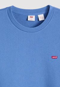 Blue cotton crewneck sweatshirt featuring ribbed neckline and a small red Levi's logo patch on the chest. Standard fit, textured interior.