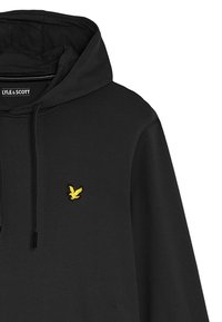 Felpa nera con cappuccio e logo di un'aquila gialla sul lato sinistro del petto. Tessuto morbido; dotata di cappuccio con cordino e vestibilità ampia.
