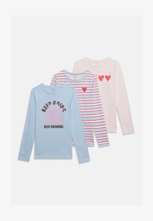 Trois chemises à manches longues en bleu pastel, blanc avec des rayures rouges et rose clair ; la chemise bleue a une fleur et un texte "KEEP GOING KEEP GROWING."