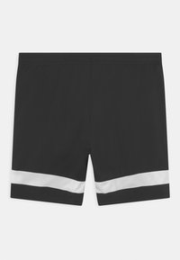 Pantalones cortos deportivos negros con una cintura elástica y una franja de malla blanca cerca del dobladillo de cada pierna.