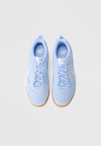Svetlo modri atletski copati z teksturiranim zgornjim delom, toniranimi vezalkami in gumijastim podplatom; na jeziku in strani je logo Nike.