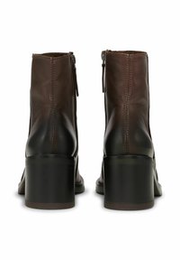 Brown leather ankle boots with a rounded toe, back zipper closure, and a chunky black heel. Features subtle stitching and smooth texture.