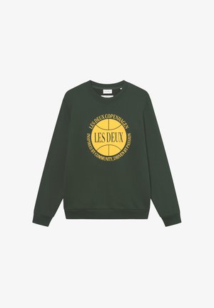 Zöld kapucnis sweatshirt hosszú ujjakkal és kerek nyakkivágással, sárga szöveggel és kör alakú grafikai mintával az elején.