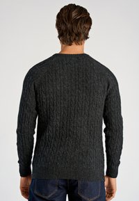 Ciemnoszary sweter w sploty z okrągłym dekoltem i ściągaczami na rękawach. Strukturalny wzór nadaje tkaninie głębię.