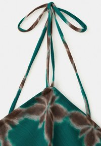 Batik-Halfter-Bikinioberteil in Türkis und Braun mit langen Trägern, die zu einer Schleife gebunden sind, auf weißem Hintergrund.