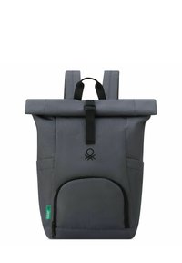 Mochila gris tipo roll-top con hardware negro, un bolsillo frontal con cremallera y correas ajustables. Presenta un logo en el centro delantero.