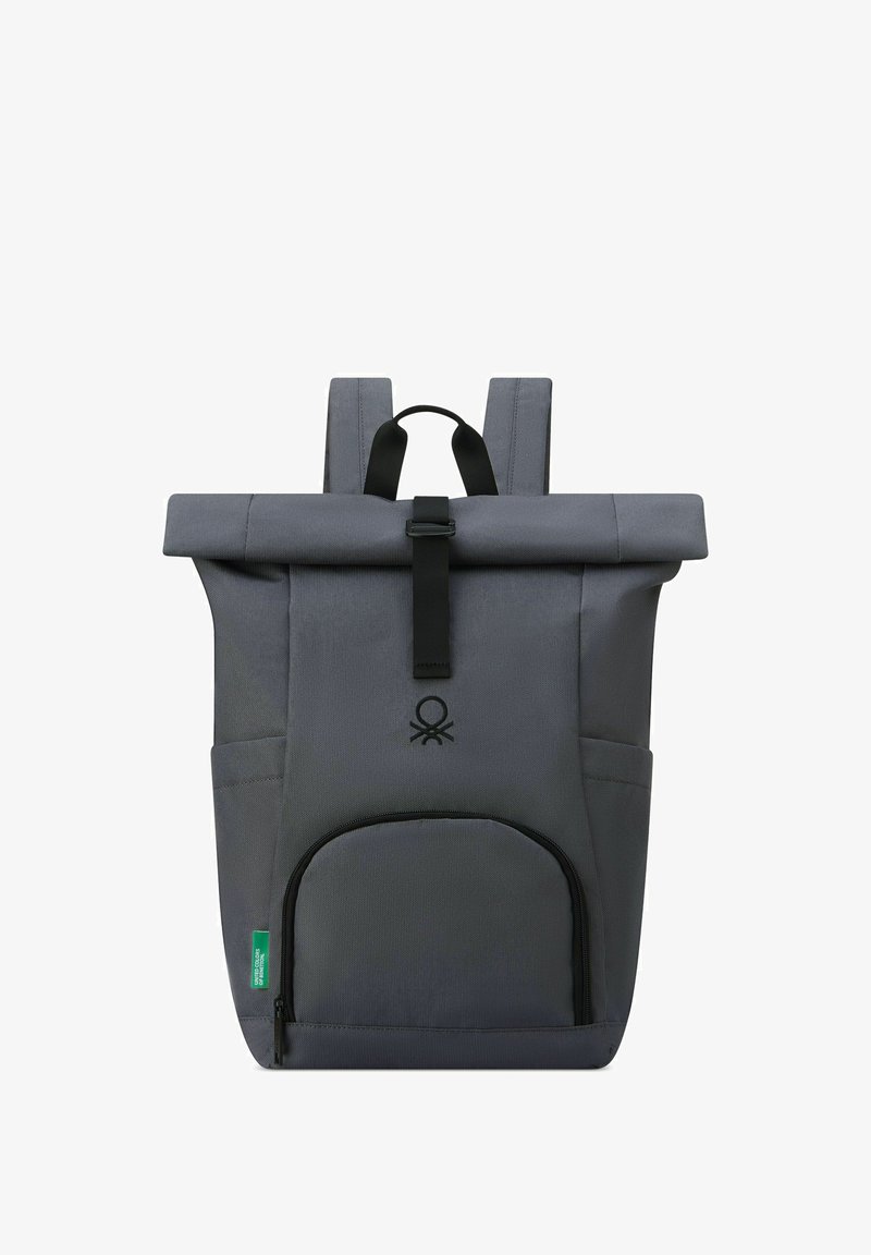 Mochila gris tipo roll-top con hardware negro, un bolsillo frontal con cremallera y correas ajustables. Presenta un logo en el centro delantero.