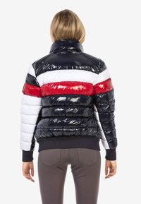 Padded Jacke mit hohem Kragen, ausgestattet mit glänzenden Streifen in Marineblau, Weiß und Rot. Gerippter Saum und Bündchen mit glatter Textur.