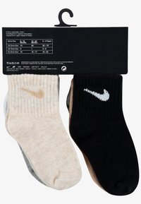 Sett med fem par ankelkorte sokker i krem, grå, beige og svart, med ribbestruktur og Nike-logo i kontrasterende farger.