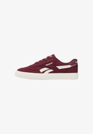 Bordeauxrode lage Reebok sneaker met witte zijstrepen, witte zool, veters aan de voorkant en Reebok-logo op de zijkant, tong en hiel.