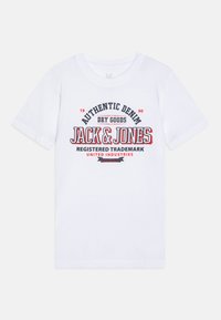 Bijela pamučna majica kratkih rukava sa crveno-plavim grafičkim otiskom. Tekst uključuje "JACK & JONES" i "AUTENTIČNI DENIM."