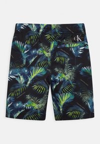 Calções de banho pretos com um vibrante padrão de folhas de palma em verde e azul, com o logótipo da Calvin Klein e um bolso nas costas.