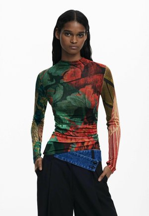 Long-sleeve top in multicolored floral print with a fitted design; features gathered texture and a contrasting blue denim accent at the waist.