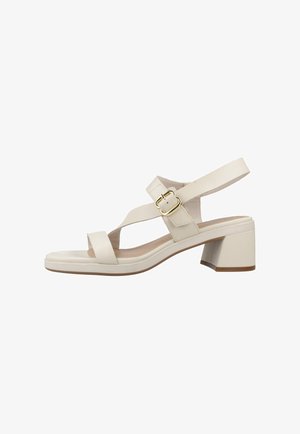 Sandalia beige de punta abierta con tacón ancho, correa ajustable en el tobillo y hebilla dorada sobre fondo blanco.