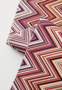 Două mostre de țesătură cu un model în zigzag în nuanțe de mov, roz, portocaliu și alb, cu o suprafață texturată și linii negre contrastante.