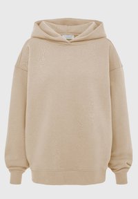 Beige oversized hettegenser med en teksturert stoff, stor hette, senkede skuldre og ribbede mansjetter og bunn. Glatt, myk utseende.