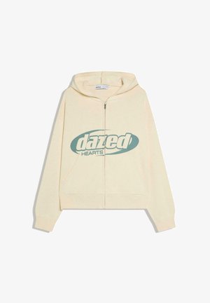 Kremfarvet hoodie med lynlås og frontlomme med "dazed HEARTS"-logo i blågrøn tværs over brystet, vist på hvid baggrund.