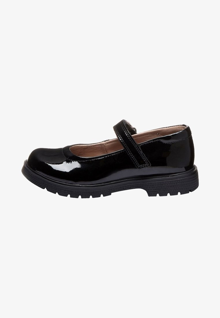 Black patent leather Mary Jane shoe with thick rubber sole and single Velcro strap, shown from the side on a white background.