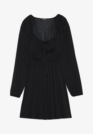 Robe noire à manches longues, col rond et taille à cordon. Fabriquée dans un tissu texturé avec des détails froncés aux épaules.