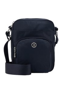 Kompaktowa, granatowa torebka crossbody z przednią kieszenią na zamek, regulowanym paskiem oraz srebrnym okrągłym logo na przednim panelu.