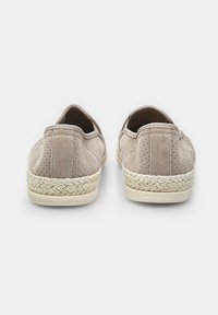 Beige velúr slip-on cipők texturált felülettel és szőtt juta talpakkal, lekerekített hátsó résszel és elasztikus nyílással.