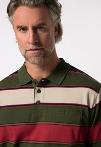 Korte mouwen polo shirt in groen met horizontale strepen in beige, rood en marineblauw. Voorzien van een kraag, knoopsluiting en een borstzak.
