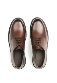 Brązowe skórzane eleganckie buty o gładkim wykończeniu, zaokrąglonym czubku, sznurowane, z teksturowaną czarną gumową podeszwą.