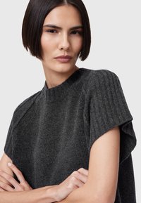 Maglione corto a maniche corte grigio scuro in maglia con texture a coste e un collo alto e arrotondato. Presenta un tessuto morbido e una vestibilità rilassata sulle spalle.