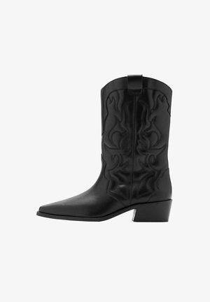 Botte de cowboy en cuir noir avec embout pointu, talon bloc de hauteur moyenne et couture décorative sur la tige.