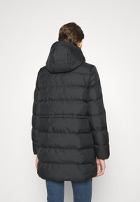 Černá péřová bunda s kapucí, s prošívaným vzorem, izolačním materiálem a střední délkou, pohled zezadu.