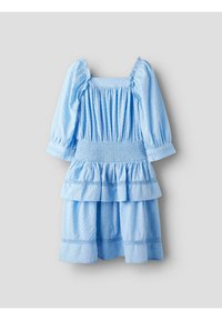 Vestito azzurro chiaro con maniche a sbuffo e scollo quadrato. Presenta una vita arricciata e due strati di volant nella gonna, tessuto dalla texture particolare.
