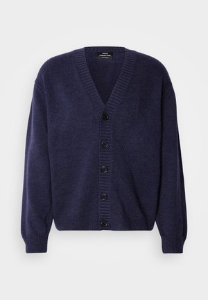 Marineblå strikket cardigan med V-hals, ribbestrikkede mansjetter og seks svarte knapper foran. Myk tekstur og avslappet passform.