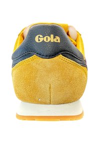 Żółte zamszowe i czarne skórzane sneakersy z wyściełanym kołnierzem, gumową podeszwą oraz złotym logo "Gola" na pięcie.