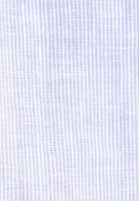 Gros plan sur un tissu blanc tissé serré avec de fines rayures verticales bleues formant un motif subtil en grille.