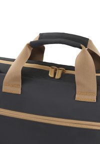Schwarze und beige Stofftasche mit zwei beigen Traggriffen und einem beigen Reißverschluss oben sowie an der Vordertasche.