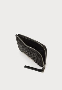 Portafoglio in pelle nera con design trapuntato, due scomparti con zip argentata e un bracciale per una facile gestione.
