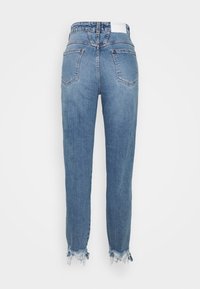 Jean bleu taille haute avec poches arrière et ourlets effilochés, vu de dos sur un fond blanc.