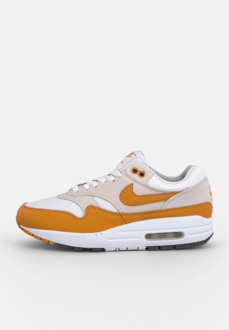 Nike Air Max 1 sneaker met een witte mesh bovenkant, oranje leren accenten en een gevoerde kraag. Air-unit in de zool, met een gestructureerde rubberen buitenzool.