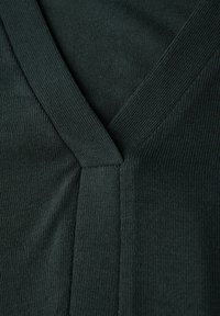 Pull en tricot vert foncé avec un col en V et des bordures côtelées. La texture est lisse avec des motifs de tricot horizontaux sur le tissu.