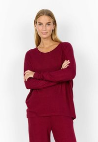 Bordeaux, lange mouwen, losvallend top met een ronde halslijn en een zachte textuur, gecombineerd met bijpassende onderkleding. Eenvoudig en modern ontwerp.