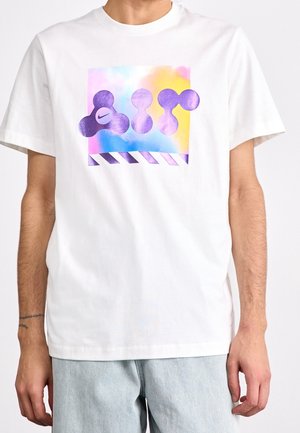 Weißes Baumwoll-T-Shirt mit einem farbenfrohen, abstrakten Grafikdruck in Lila und einem gestreiften Akzent am unteren Rand. Klassischer Rundhalsausschnitt.