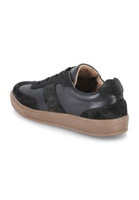 Czarne sneakersy wykonane z gładkiej skóry i fakturowanej zamszowej, z brązową gumową podeszwą i czarnymi sznurówkami zapewniającymi bezpieczne dopasowanie.