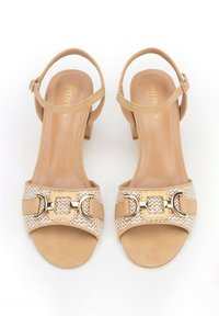 Beige Absatzsandalen mit gewebtem Obermaterial, goldenen Hardware-Akzenten und verstellbaren Knöchelriemen, die eine glatte samtartige Textur aufweisen.