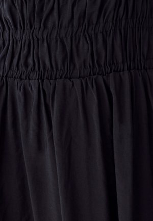 Mustast kangast, millel on elastne voltimine, mis loob kogutud, tekstuuriga horisontaalseid vöötmeid ja pehmet langevat kangast allpool.