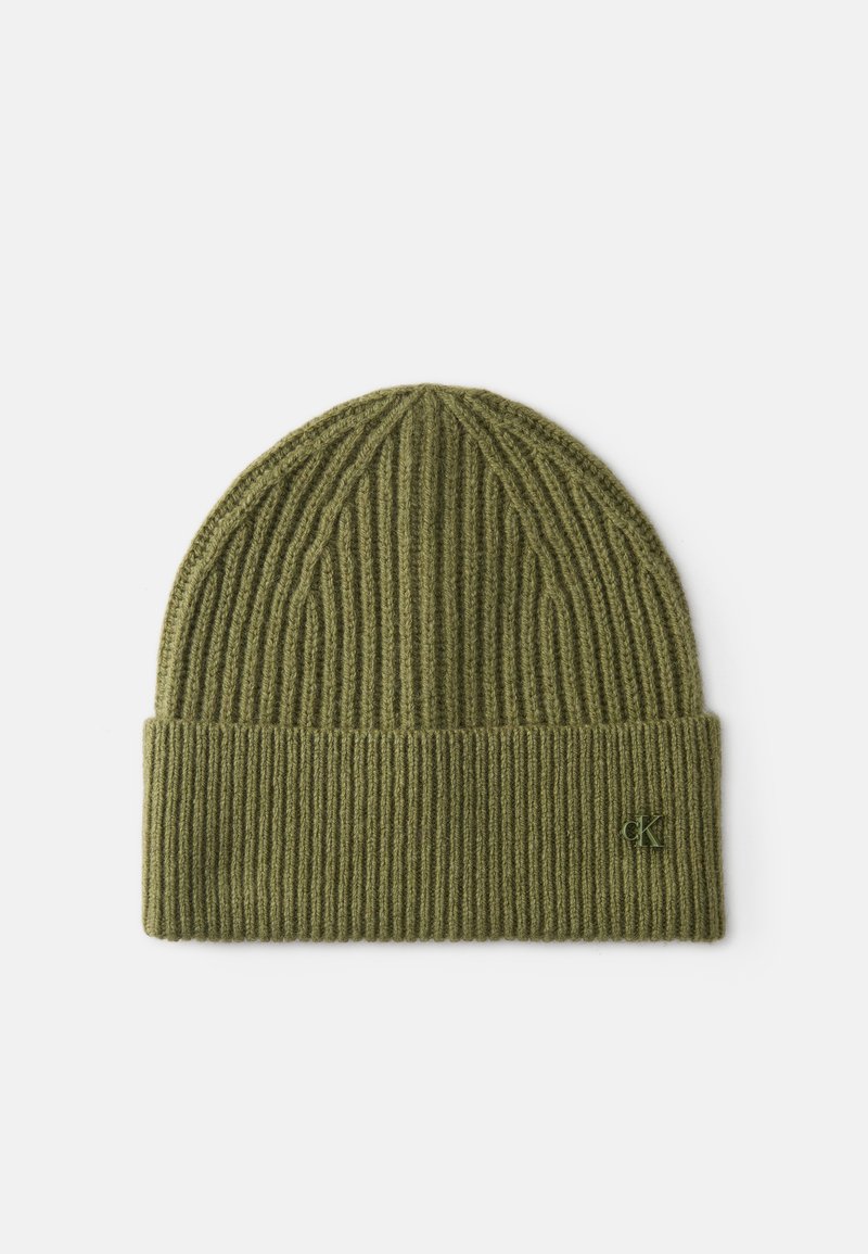 Gorro de malha canelada verde-oliva com a barra dobrada e um pequeno logotipo em relevo na frente. O material parece macio e texturizado.