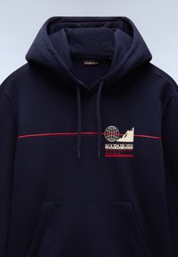Sudadera con capucha azul marino con bolsillo delantero, capucha con cordón y gráfico en el pecho que muestra un globo y montañas en tonos crema y detalles en rojo.