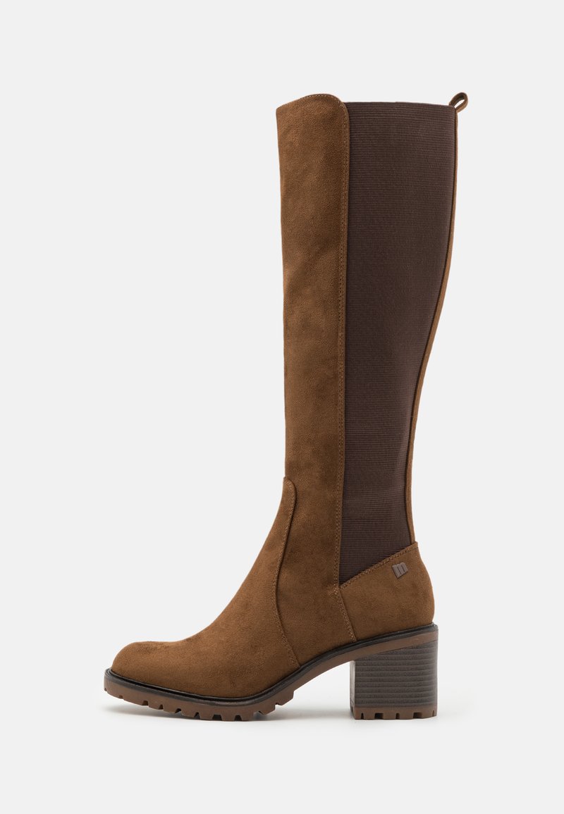 Brown suede knee-high boot with a brown elastic panel, slightly tapered shape, and a textured block heel. Grooved sole for traction.