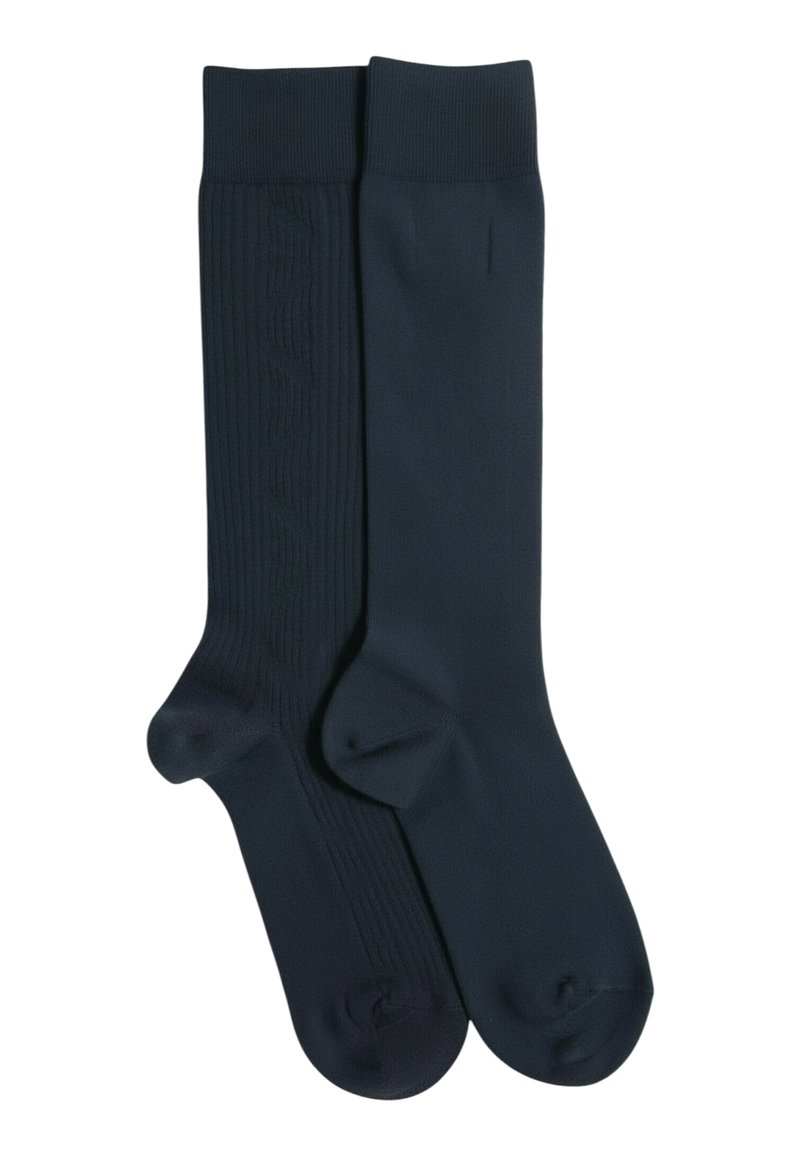 Calcetines azul marino, uno con textura acanalada y detalle de logo, el otro liso. Ambos hasta la rodilla con puntera y talón reforzados para mayor durabilidad.